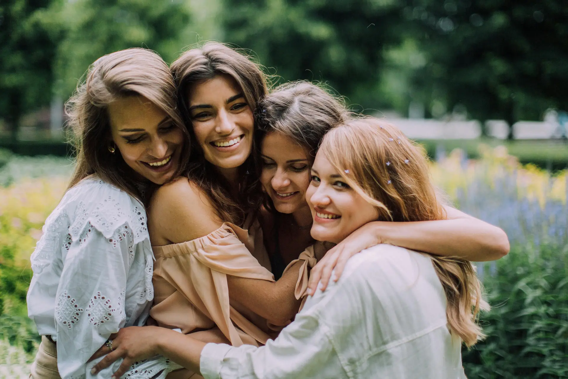 4 women hugging each other.