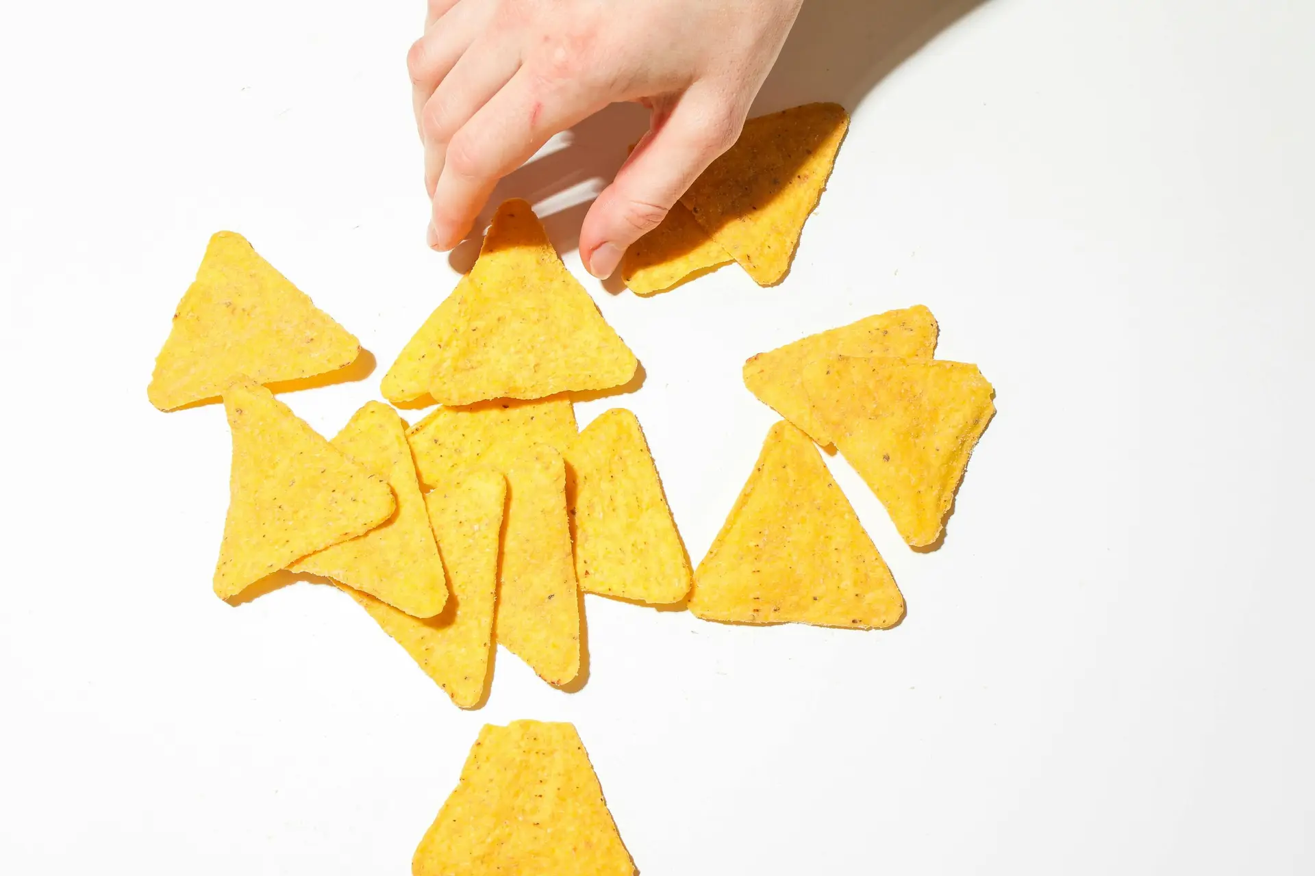 A person going for some corn chips.
