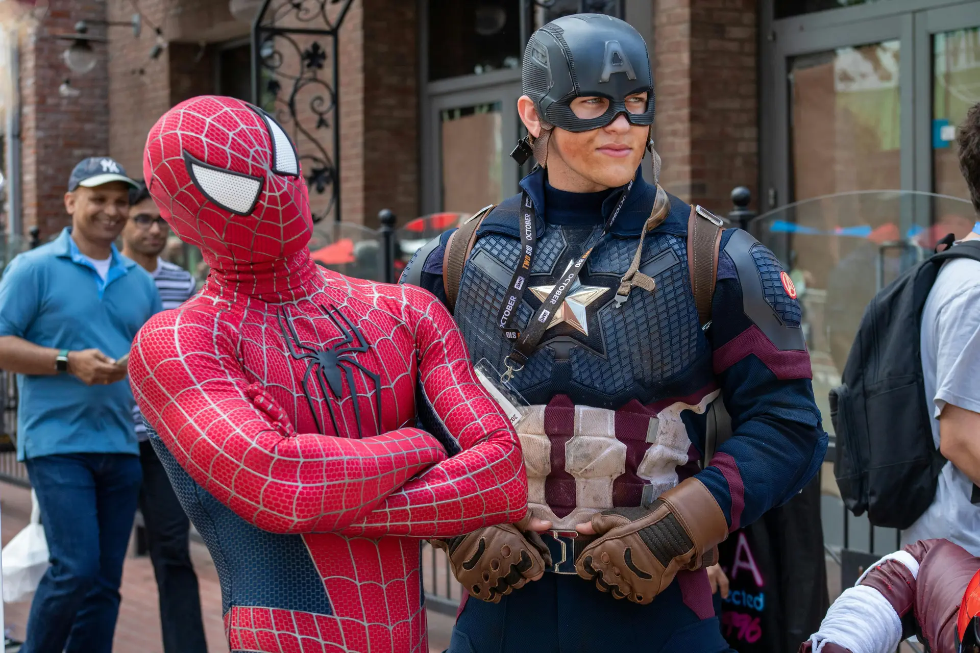 Two people cosplaying as spiderman and captain america.