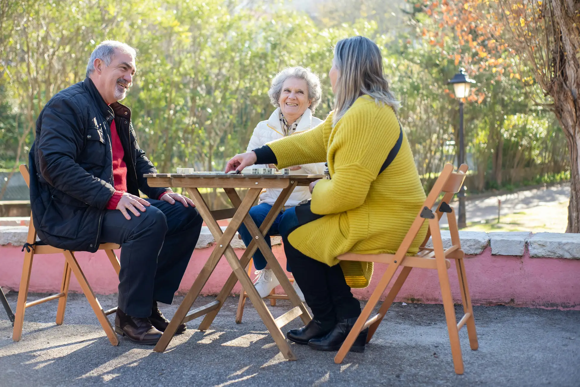 A group of mixed-age people, possibly neighbors, sitting and chatting with each other.