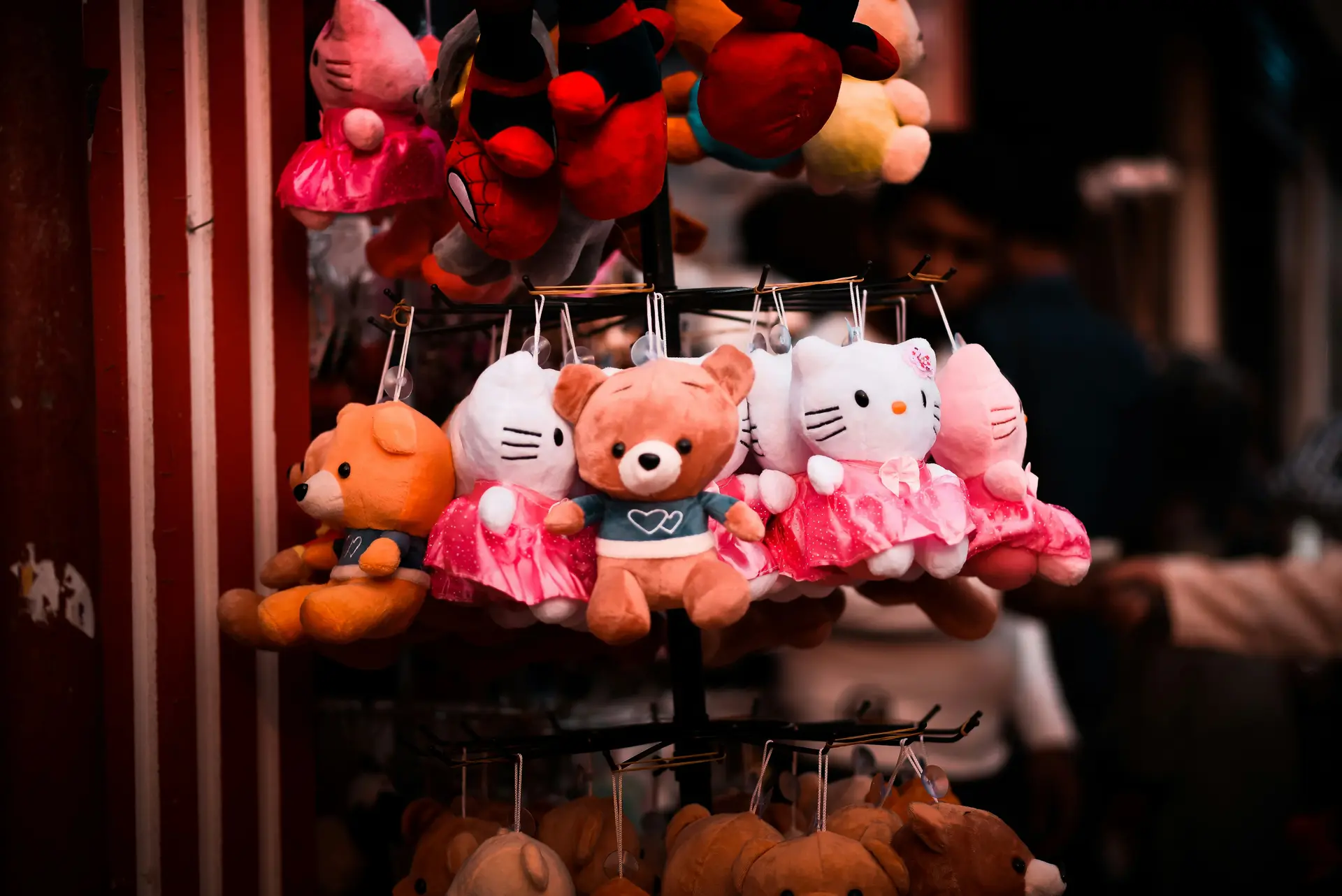 Bunch of teddy bears are hanged in a shop.