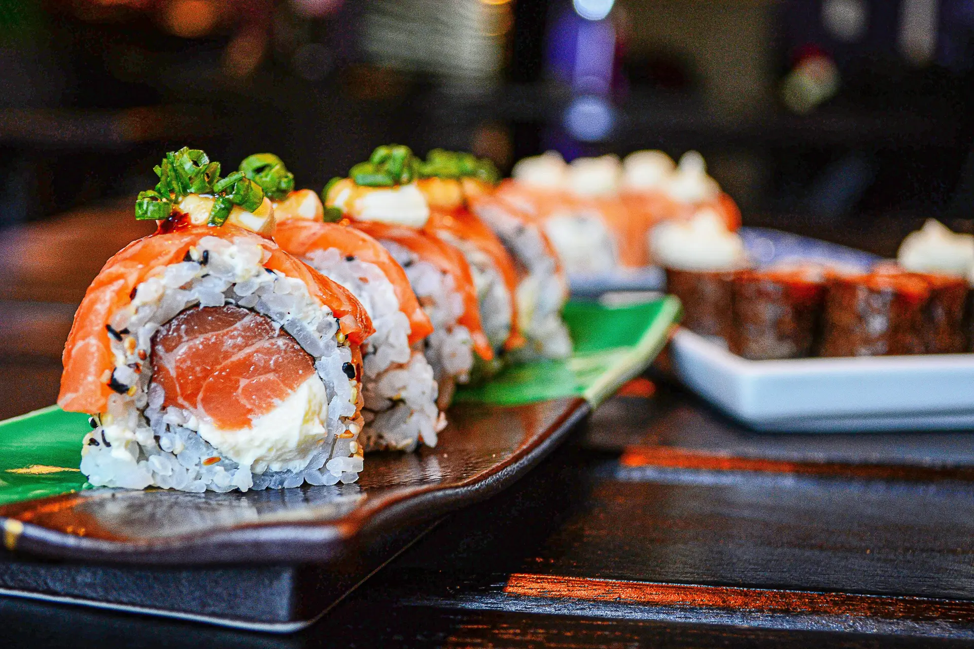 Sushi rolls on red plate on a table.