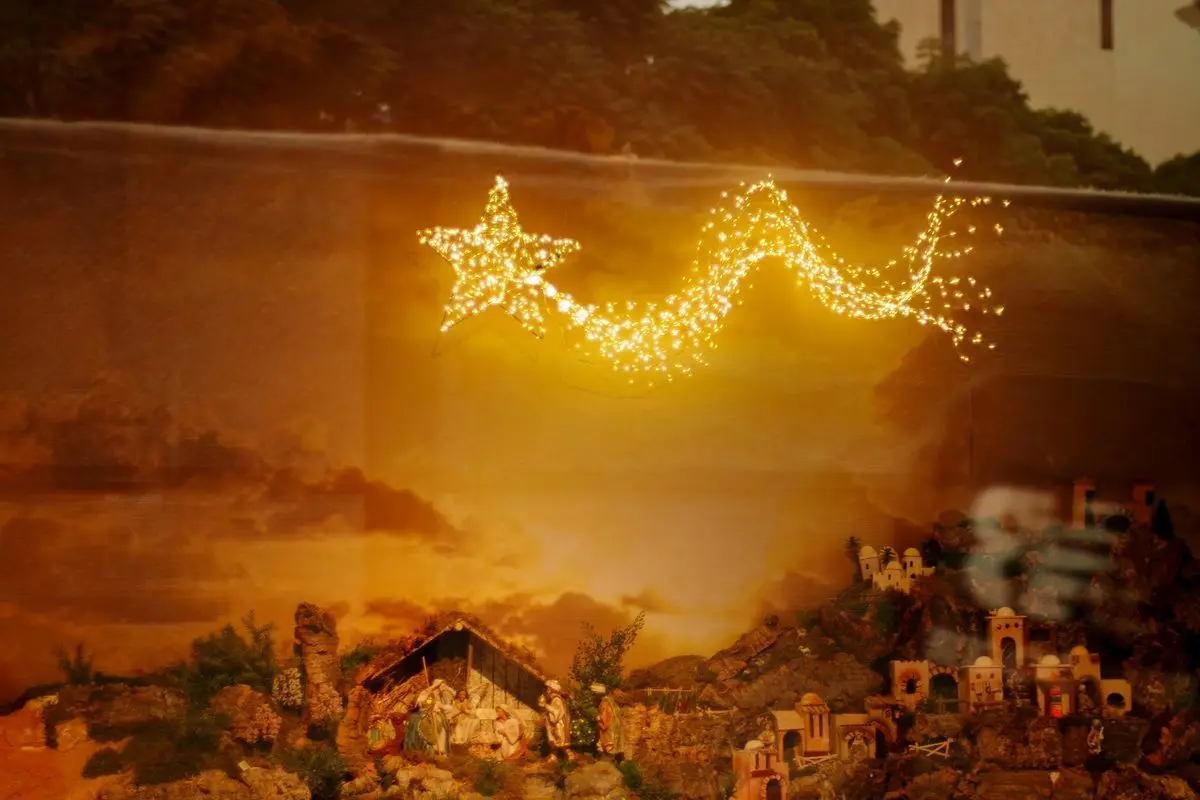 A glowing star trail over a nativity scene.