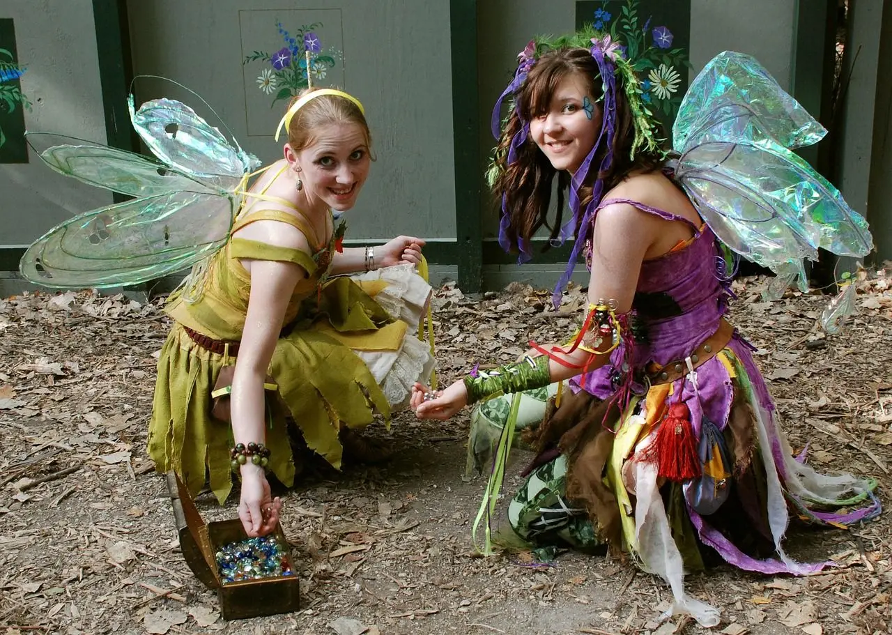 Two women dressed up as fairies. Both of wings on their backs.
