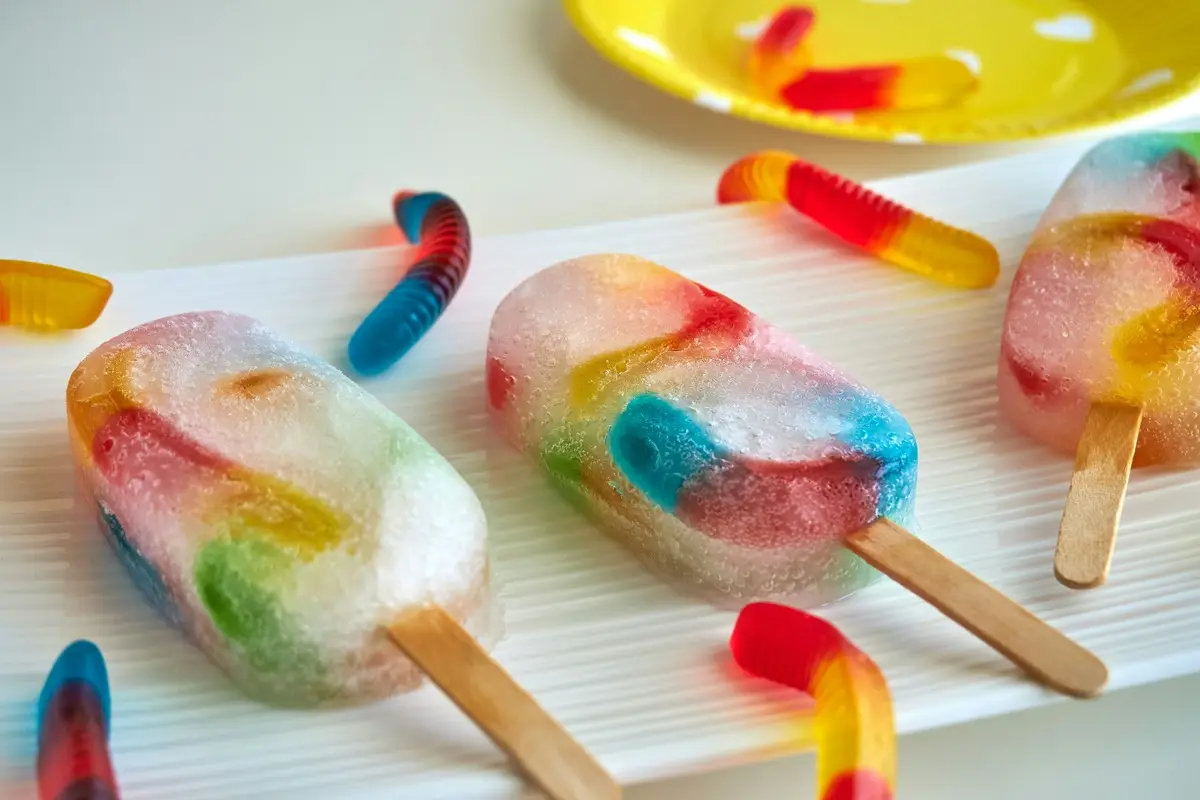 Ice cream made out of gummy worms on a white plate.