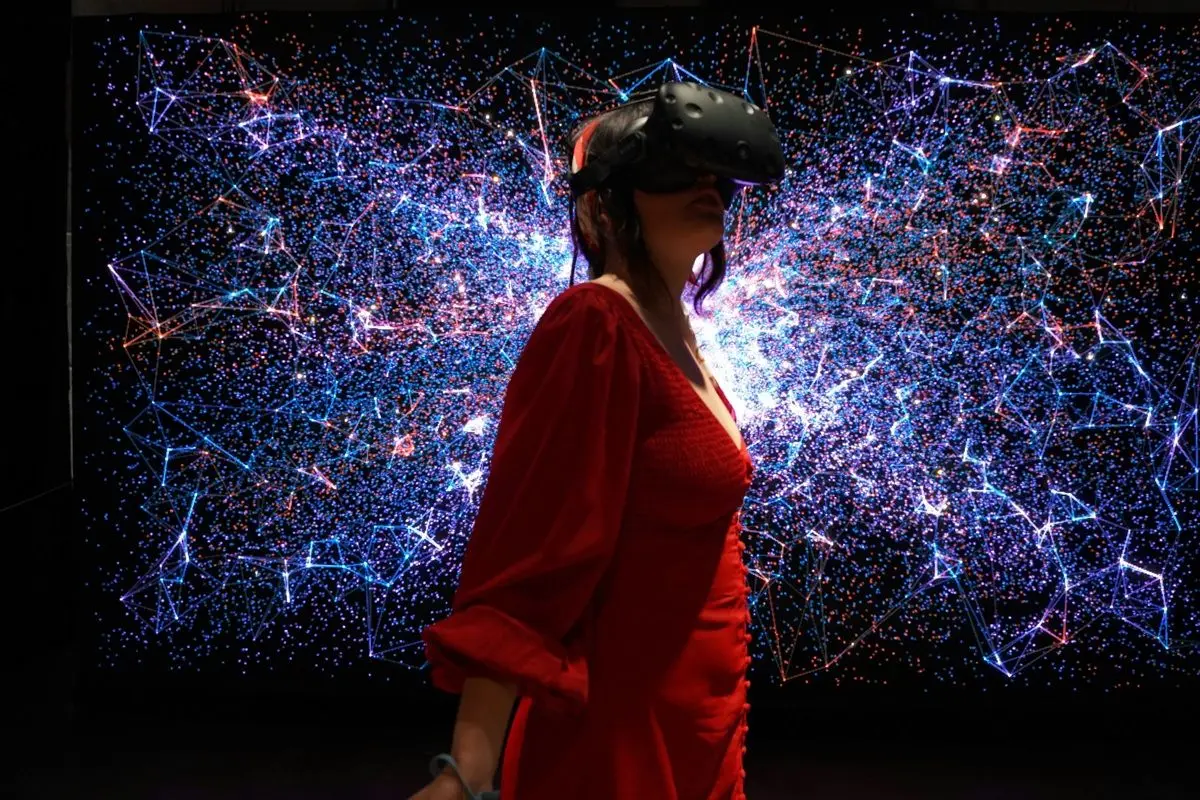 A woman in a red dress wearing a virtual reality headset.