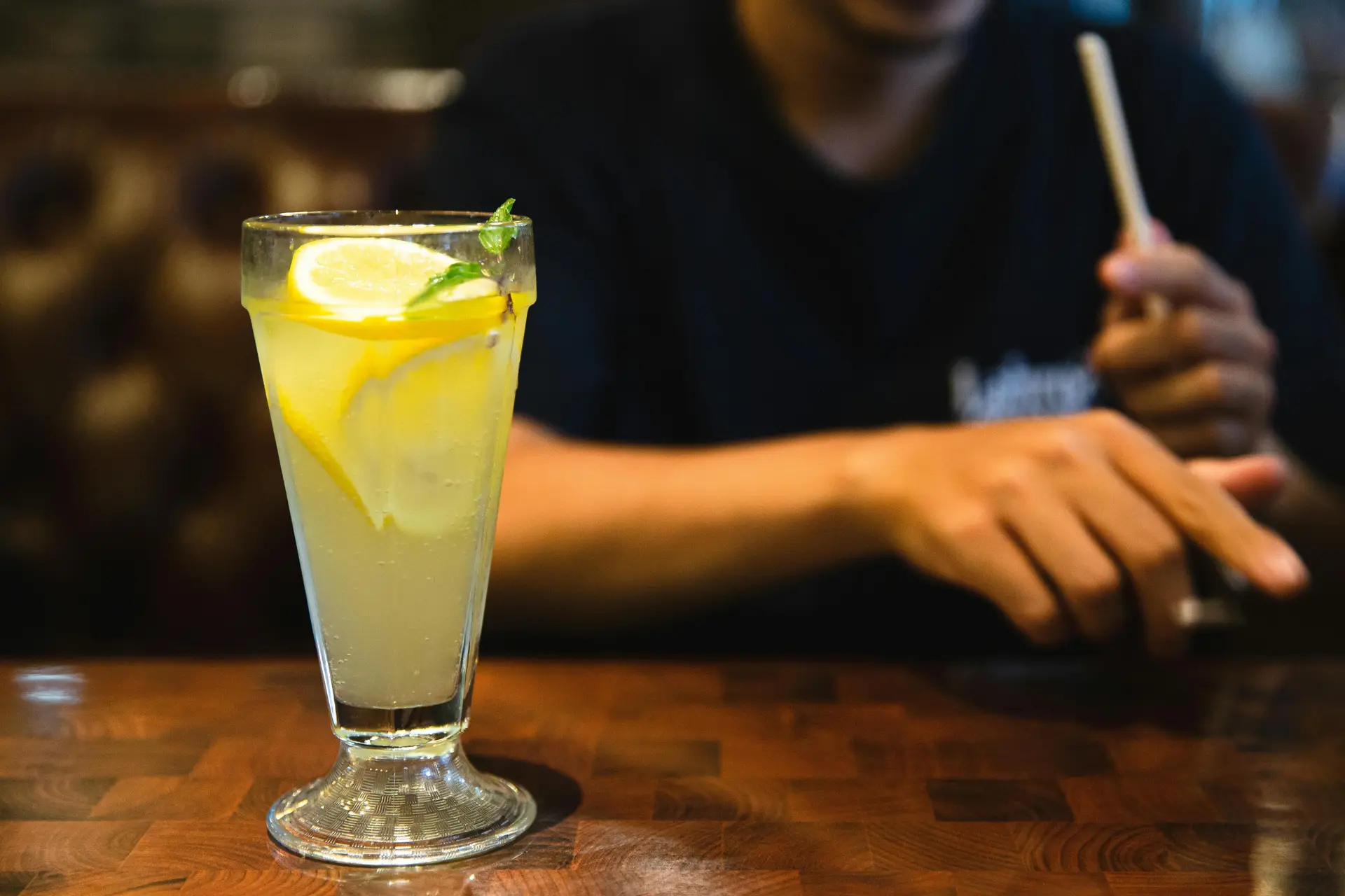 A tall glass of lemon juice on a wooden table.