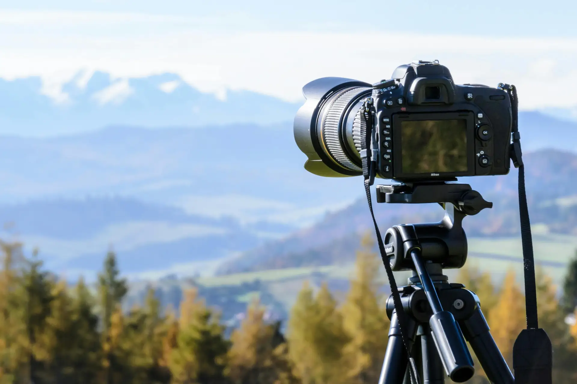 A camera in focus that is placed on a mountain.