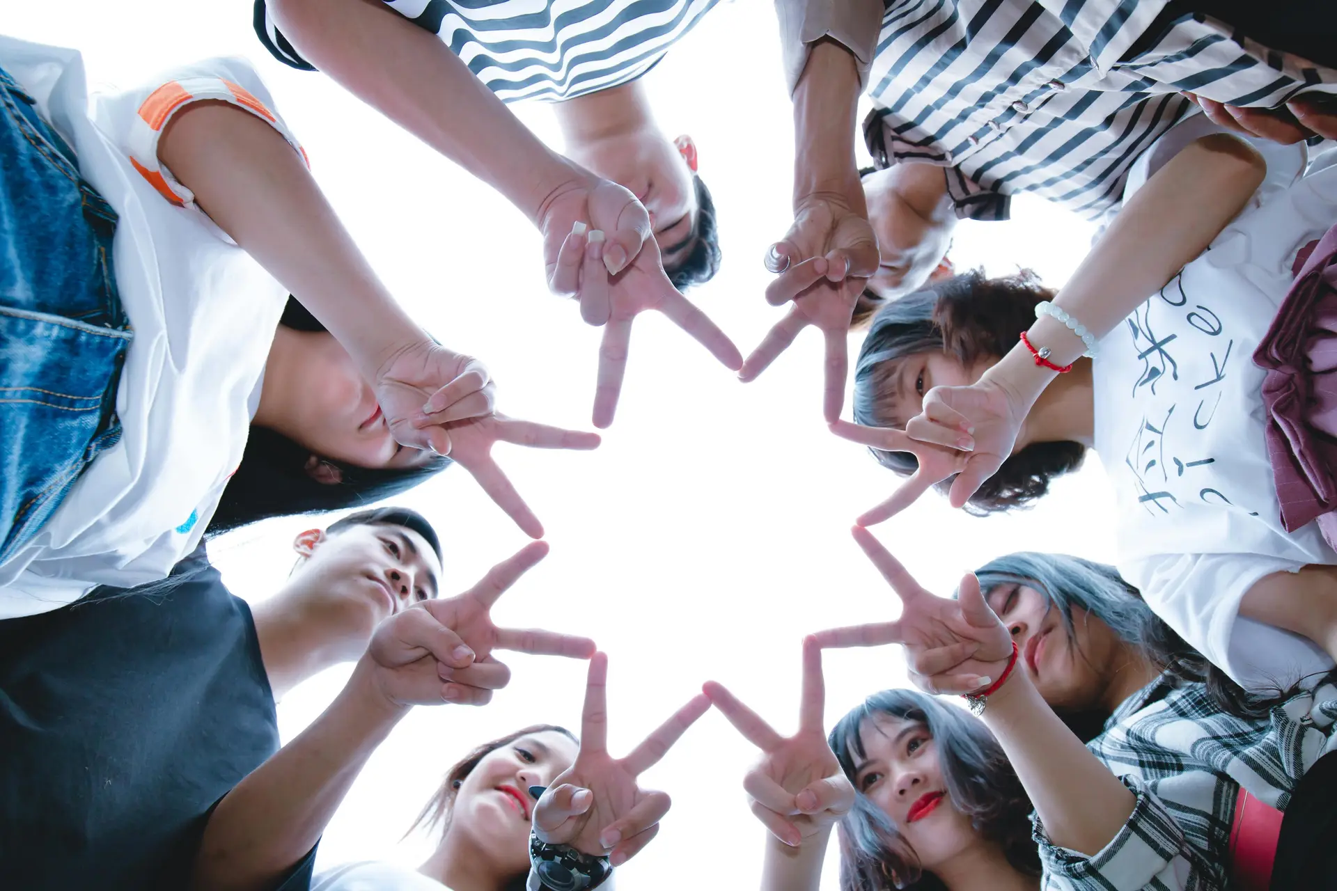 A group of youth forming start with their hands.