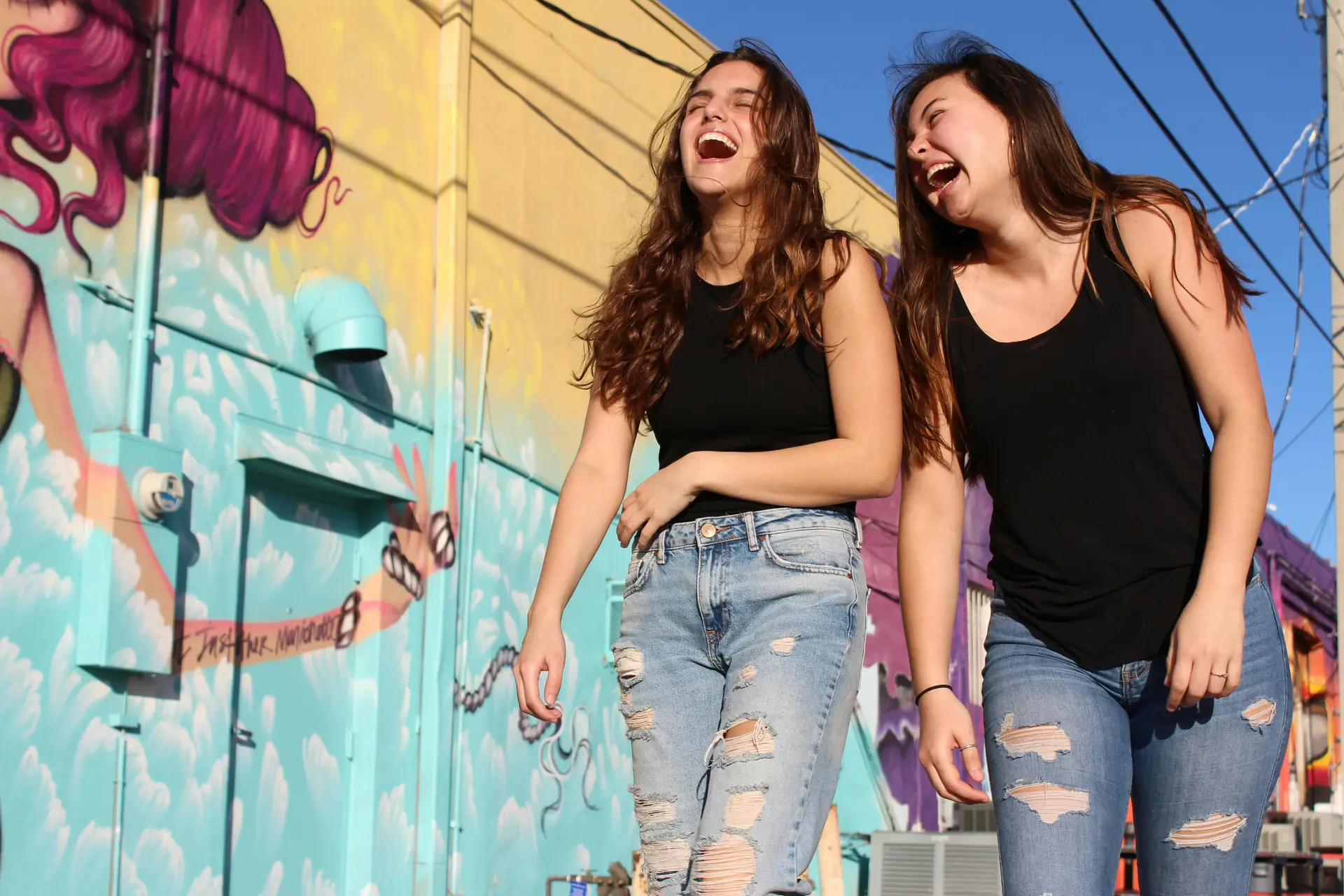 Two women laughing while walking.