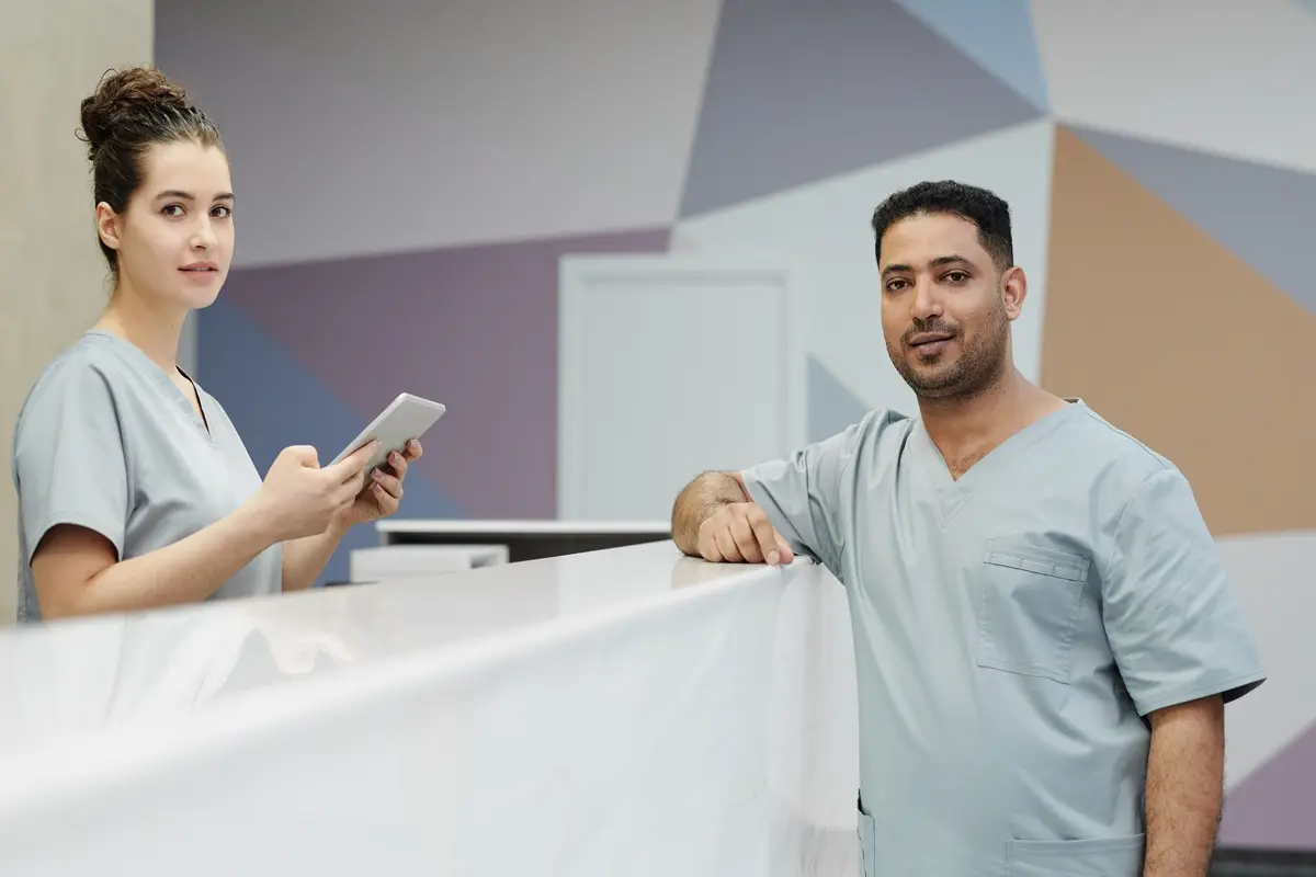Nurses in scrub suits at a modern clinic's reception area.