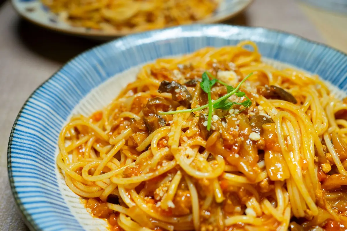 A delicious spaghetti dish in tomato sauce with mushrooms and herbs