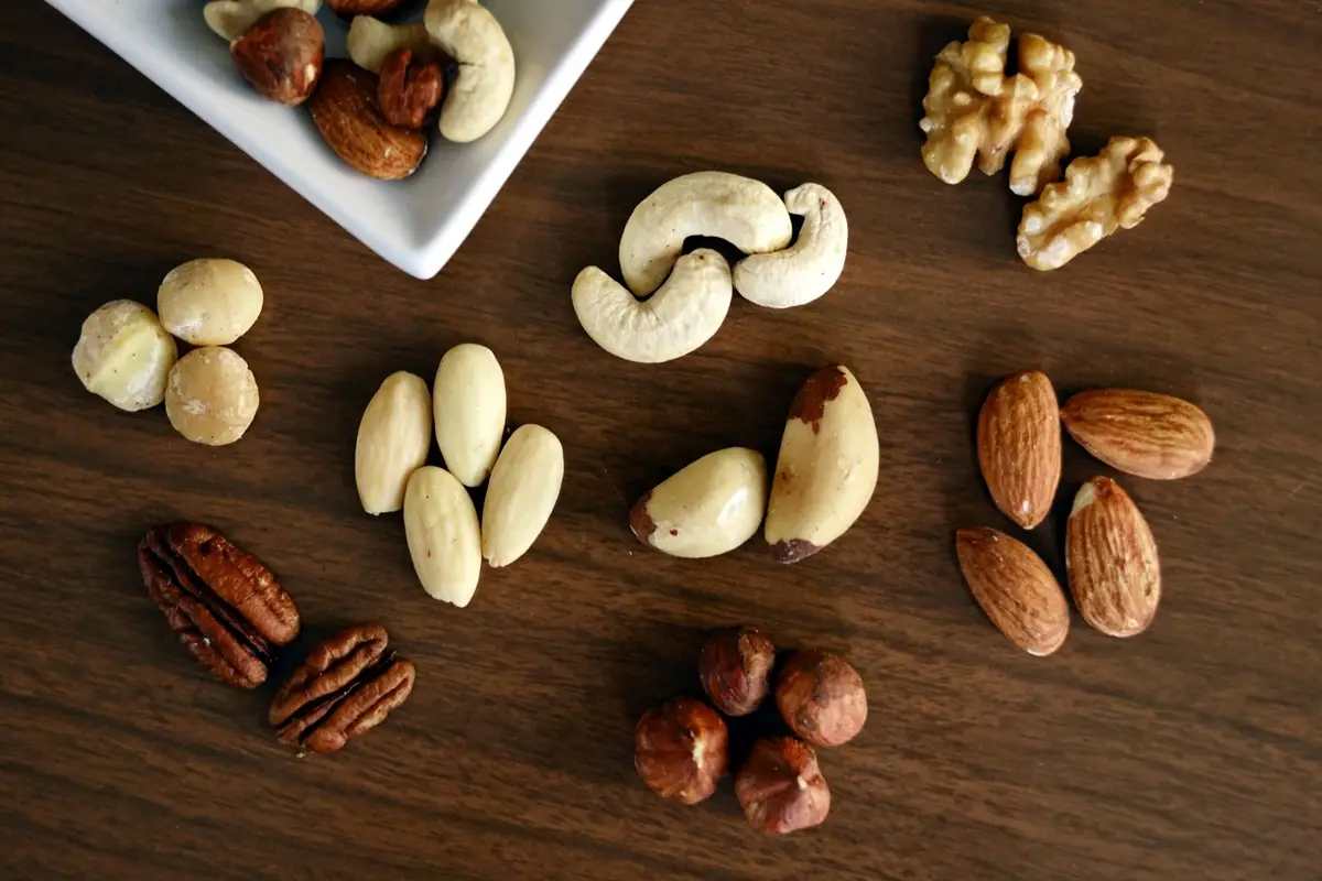 various nuts on a wooden table, showcasing healthy snacking options.