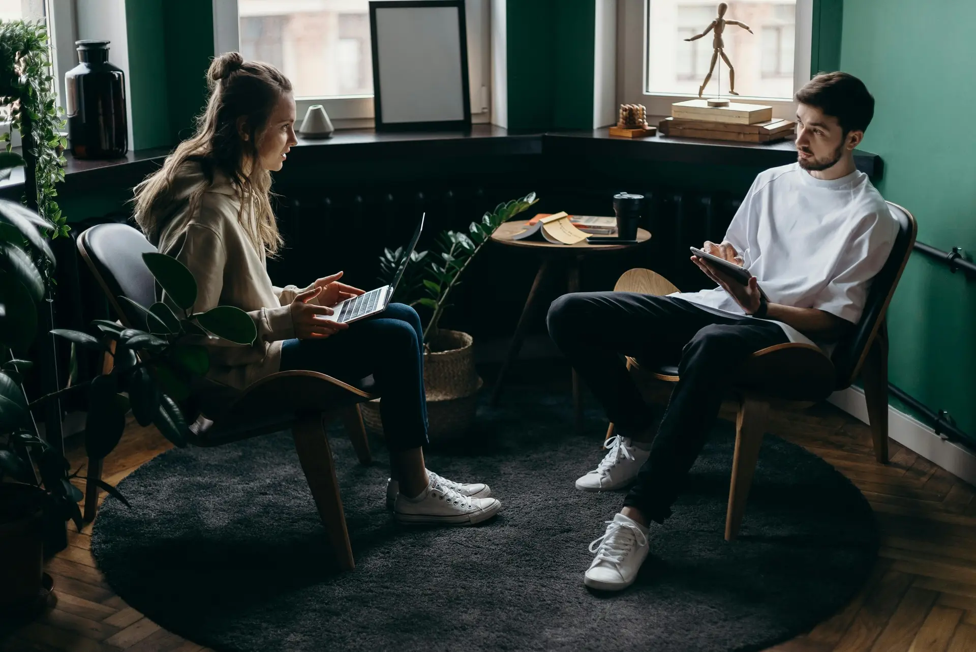 A girl and a boy exchanging ideas together at living room.
