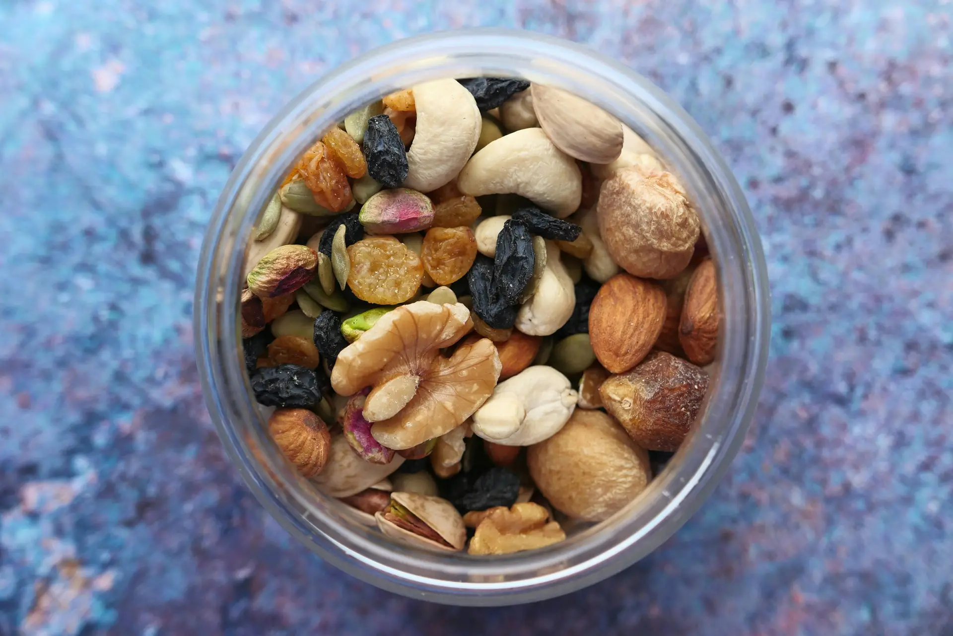 An assortment of different types of nuts, seeds, and chocolate in a jar.