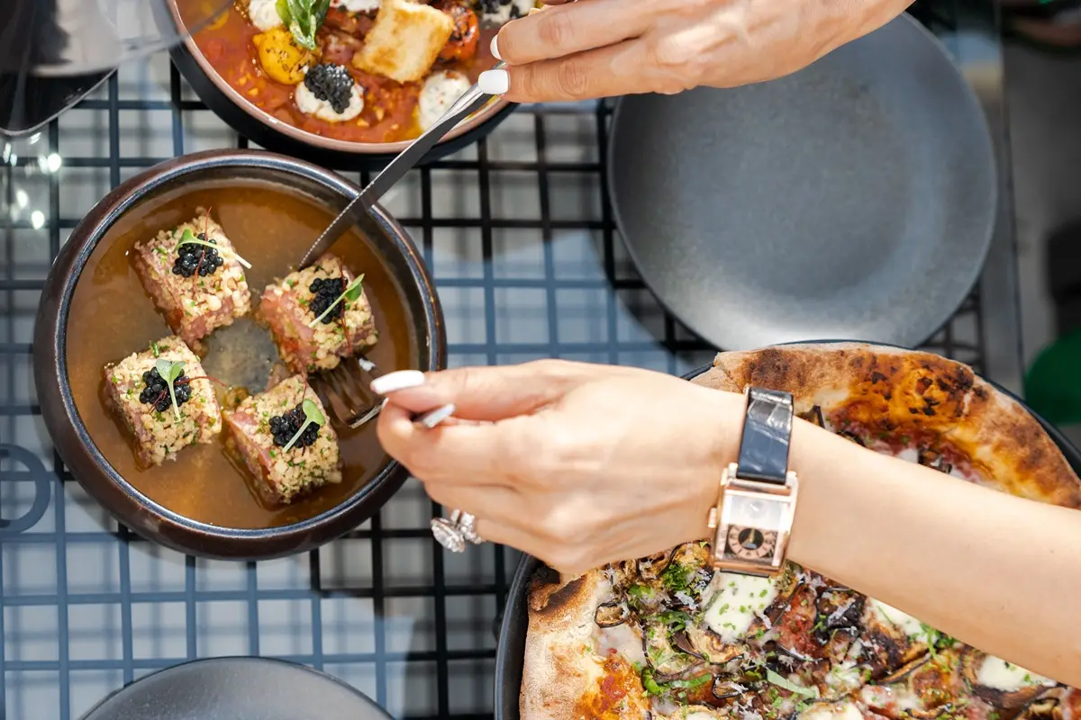 A luxurious meal with caviar and pizza at a restaurant.