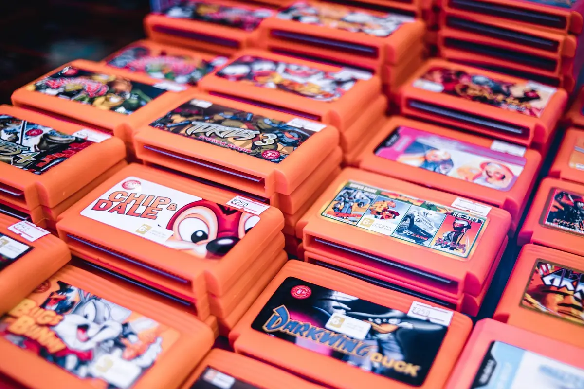 Stacked retro video game cartridges in orange cases, showcasing popular titles to play on National Video Game Day.