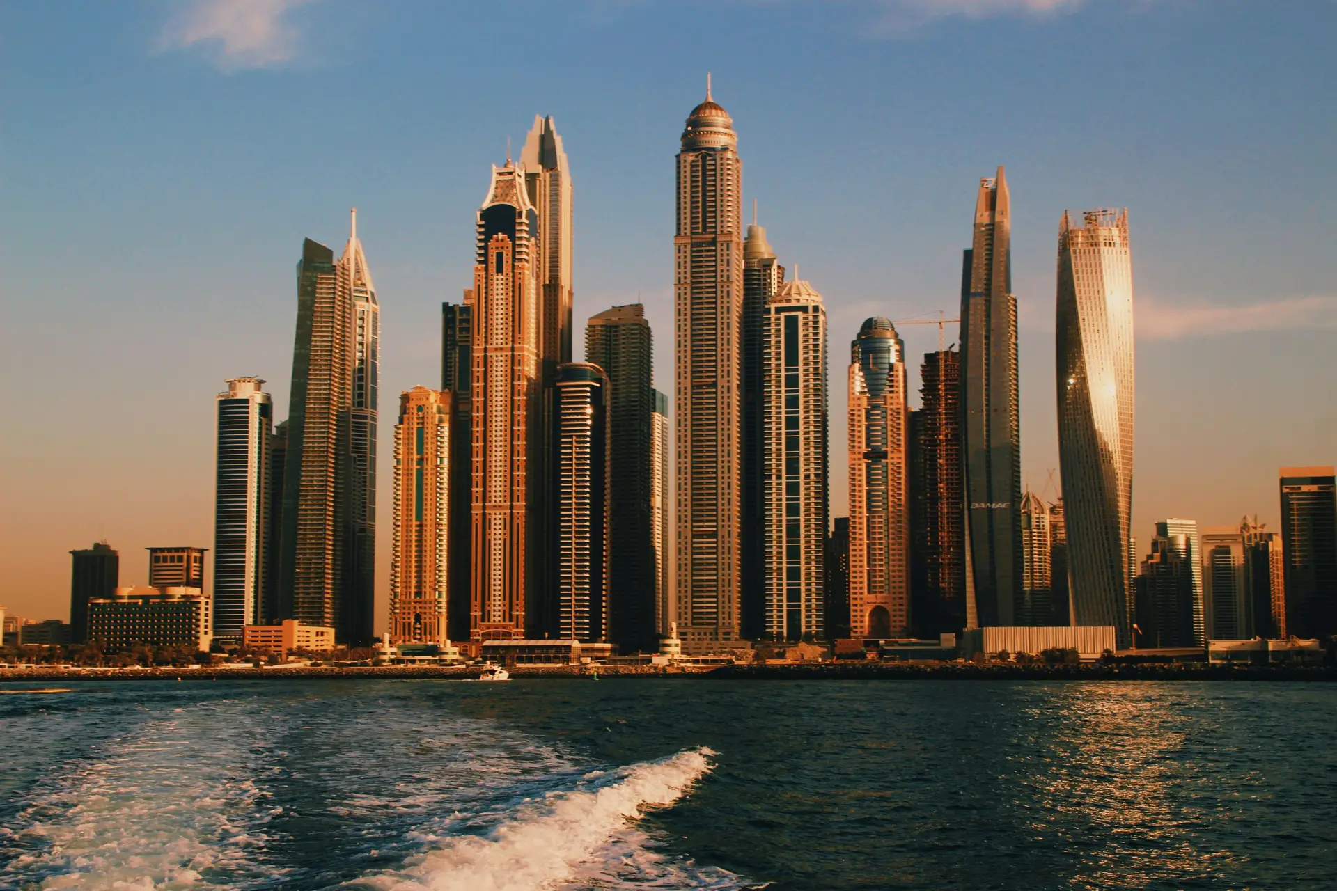 High rise buildings near sea during sunset.